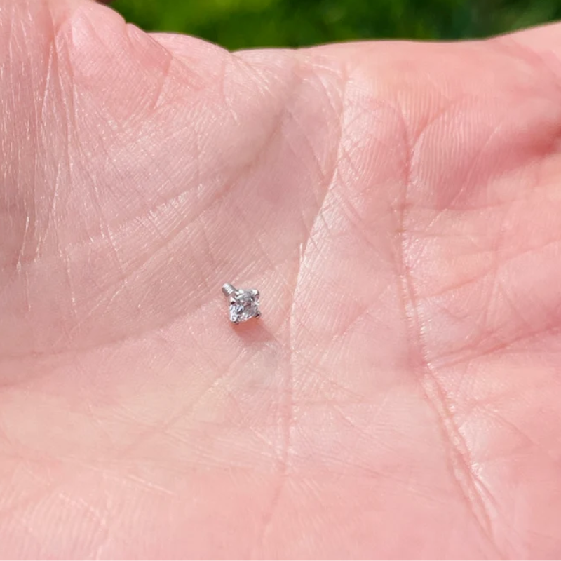 14K gold dermal anchor stud with natural diamond shown in piercing