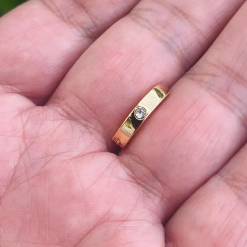 Front view of 14K gold belly button clicker with genuine diamond bezel setting