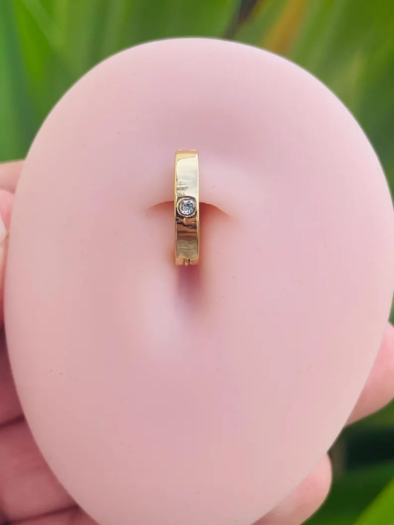 14K gold belly button clicker ring with bezel set diamond shown in navel piercing